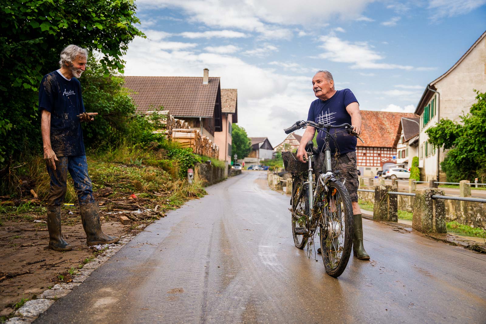 Ein Bewohner des Dorfes Schleitheim im Kanton Schaffhausen, hat gerade sein Fahrrad nach einem verherenden Hochwasser aus dem Dorfbach gefischt.
